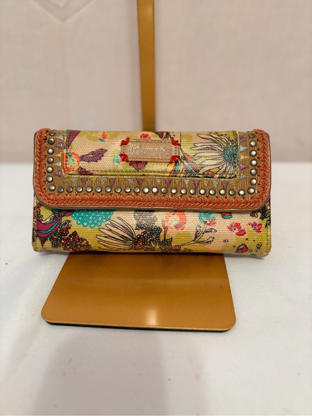 Sakroots trifold wallet featuring a vibrant multicolored floral design